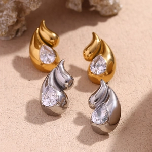 Close-up of gold and silver teardrop earrings with pear-cut cubic zirconia stones