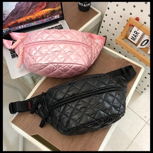 Quilted nylon waist bags in pink and black colors shown on a desk for lifestyle view