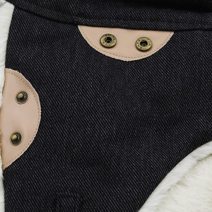 Detail of warm winter hat featuring black twill fabric, faux fur lining and metal button