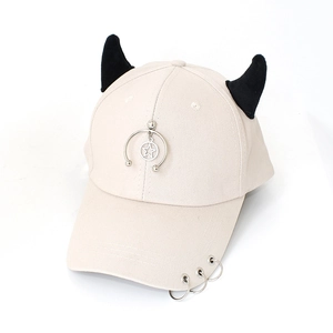Detail of off-white baseball cap featuring black devil horns and silver metal star charm