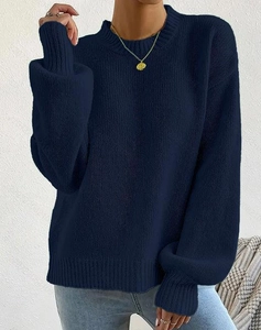Detail shot of navy blue cable knit texture and crew neck design on long sleeve sweater