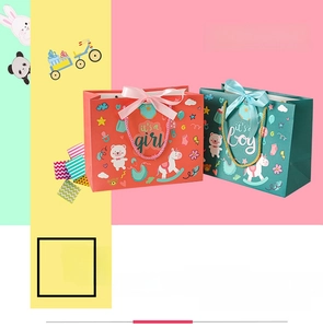 Detail view of colorful paper gift bags featuring pink girl and blue boy designs with ribbons