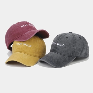Three washed cotton baseball caps in burgundy, mustard, and charcoal with Stay Wild embroidery