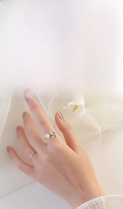 Detail of S925 sterling silver ring with white flower and zircon leaf on hand