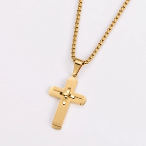 Detail of gold cross pendant featuring a textured grid pattern on a classic box chain