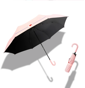 Pink heart print umbrella with black UV coating and ergonomic curved handle detail
