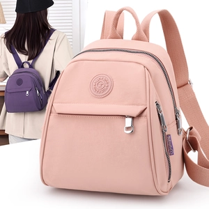 Detail of pink and purple waterproof nylon backpacks with multiple zipper compartments