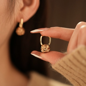 Detail showing gold plated hoop earrings with champagne crystal sphere charms