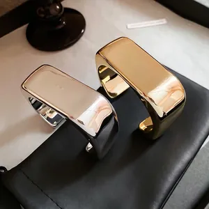 Minimalist wide wave cuff bracelets in polished gold and silver mirror finishes