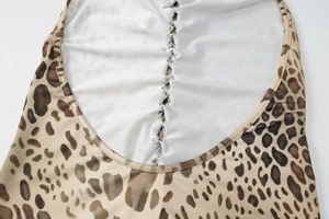 Detail of leopard print dress featuring back ruching and white lining highlights