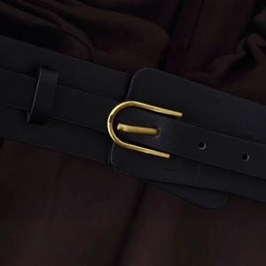Fashionable black leather midi dress belt featuring a gold horseshoe metal buckle