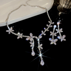Detailed view of silver butterfly necklace and fringe tassel earrings set with cubic zirconia