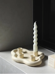 Gros plan d'un bougeoir nuage en céramique crème avec bougie spirale au style nordique