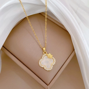 Detail of gold titanium clover necklace with white mother of pearl and crystal inlay