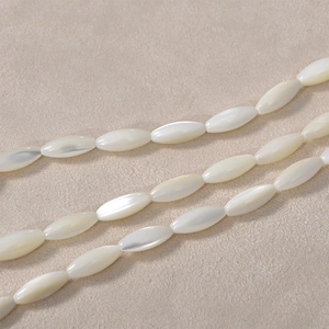 Macro shot of oval white mother-of-pearl shell beads for DIY jewelry making with iridescence