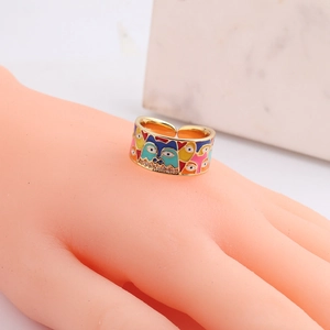 Detail of golden adjustable ring featuring colorful husky enamel and cubic zirconia