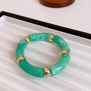 Detail of green faux marble resin segments with gold metal rings on a display tray