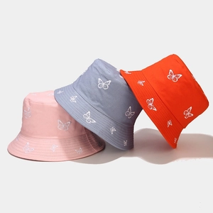 Close-up of fine butterfly embroidery on vibrant cotton canvas sun hats in three colors
