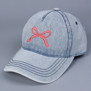 Detail der roten Schleifenstickerei auf hellblauer Denim-Baseballkappe mit Textur