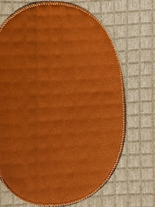 Detailed view of burnt orange suede patch with reinforced black and orange stitching