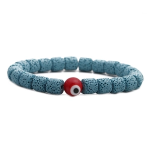Armband aus blauen Lavasteinen mit rotem Evil Eye Anhänger auf weißem Hintergrund
