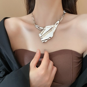 Macro shot of silver irregular wrinkled texture necklace with liquid metal effect finish