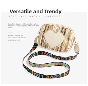 Detail view of woven straw bag featuring heart applique and colorful LOVE logo strap