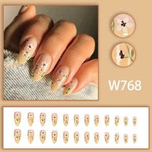 Set unghie finte a mandorla con motivi floreali bianchi e sfumatura nude elegante