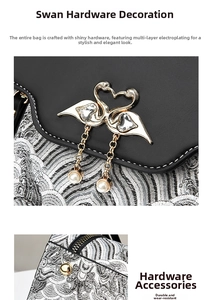 Detail of gold swan ornament with crystal and pearl on black and silver leather bag