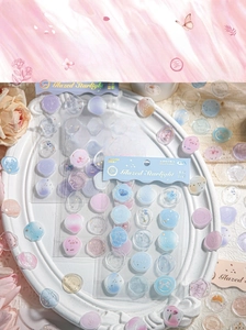 Close-up of starry glass wax seal stickers with gold foil details in a floral setup