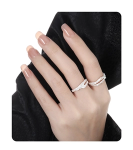 Detailed view of branch-textured silver rings with small gemstone inlay on female hand