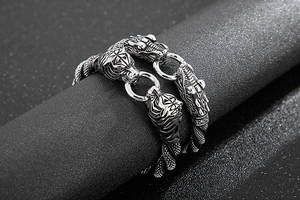 Detailed view of silver punk men's tiger and dragon head bracelets on black leather cords