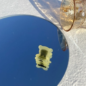 Détail d'une pince à cheveux ours en acétate jaune avec inscription France Handmade