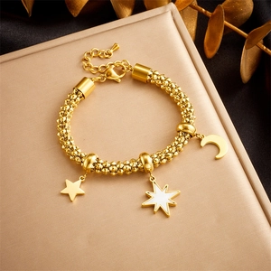 Detailed view of gold beaded chain bracelet featuring star and moon pendants on leather