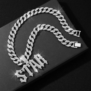 Macro shot of silver crystal-encrusted STAR pendant on a matching Cuban link chain