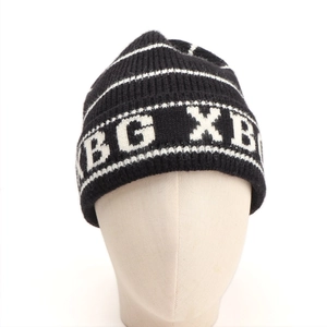 Detail of black and white striped knit beanie featuring XB G XB woven lettering