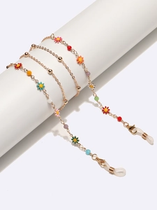 Détail de la chaîne de lunettes dorée avec marguerites en émail et boucles antidérapantes