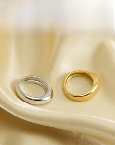 Close-up of minimalist stainless steel and 18k gold plated ring set on silk