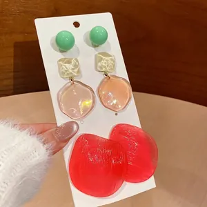 Three pairs of irregular resin geometric drop earrings in green amber and red shades