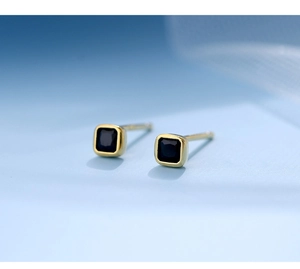 Detailed macro view of square black gemstone stud earrings with a gold plated finish