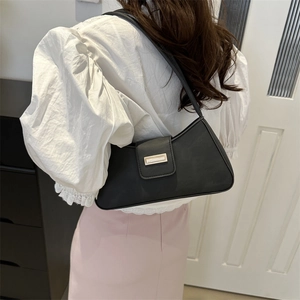 Classic black French style baguette underarm bag with gold buckle on white blouse model