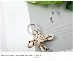 Detailed view of hand-woven beige polyester cord keychain with a durable silver metal ring