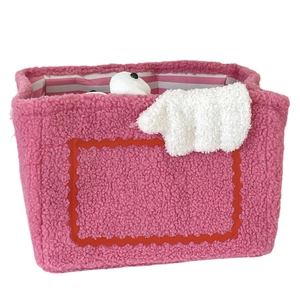 Pink plush monster storage basket with wavy frame and soft striped lining for home organizing