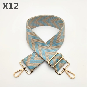 Close-up of wide woven shoulder strap with zigzag pattern and golden metal buckles