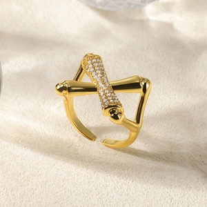 Macro detail of cross bamboo style gold ring with micro-set white zircon accents