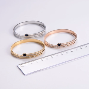 Detailed close-up of triple-colored titanium steel bracelets with water drop gemstones