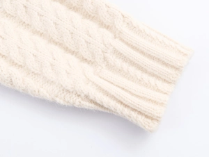Détail du pull en maille torsadée crème avec finition de poignets côtelés fins