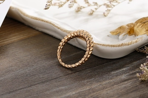 Close-up of golden croissant dome ring with spiral texture on a wooden table