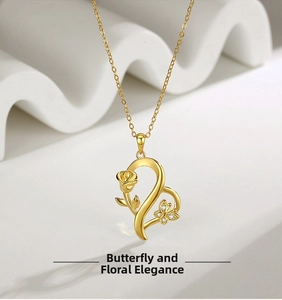 Detailed shot of golden heart pendant with rose and butterfly motifs on white stand