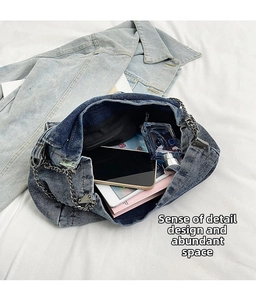 Spacious interior of dark blue denim shoulder bag with silver chain and daily essentials
